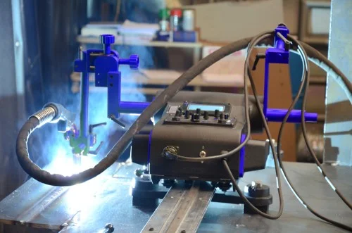 automated welding machine operating on a metal workpiece