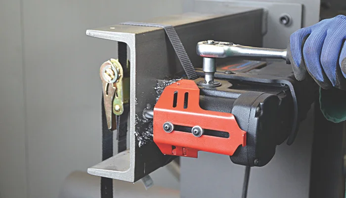 industrial belt grinder shaping a steel beam